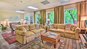 A cozy living room with two beige sofas, a wooden coffee table, and patterned rugs. - Chauga River Cabin: Pets Welcome! (Mountain Rest)