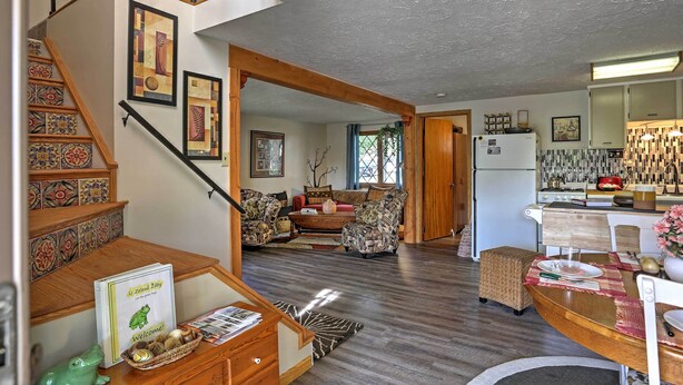 A spacious living area with a wooden staircase, a dining table, and a kitchen area. - Lakeview A-frame Steps to Marina & Old Field Beach (Lakeview)