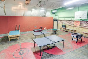 A room with ping pong tables, a foosball table, and a whiteboard with writing. - Direct Trail Access! ATV Riding Home Base in Gary (Gary)