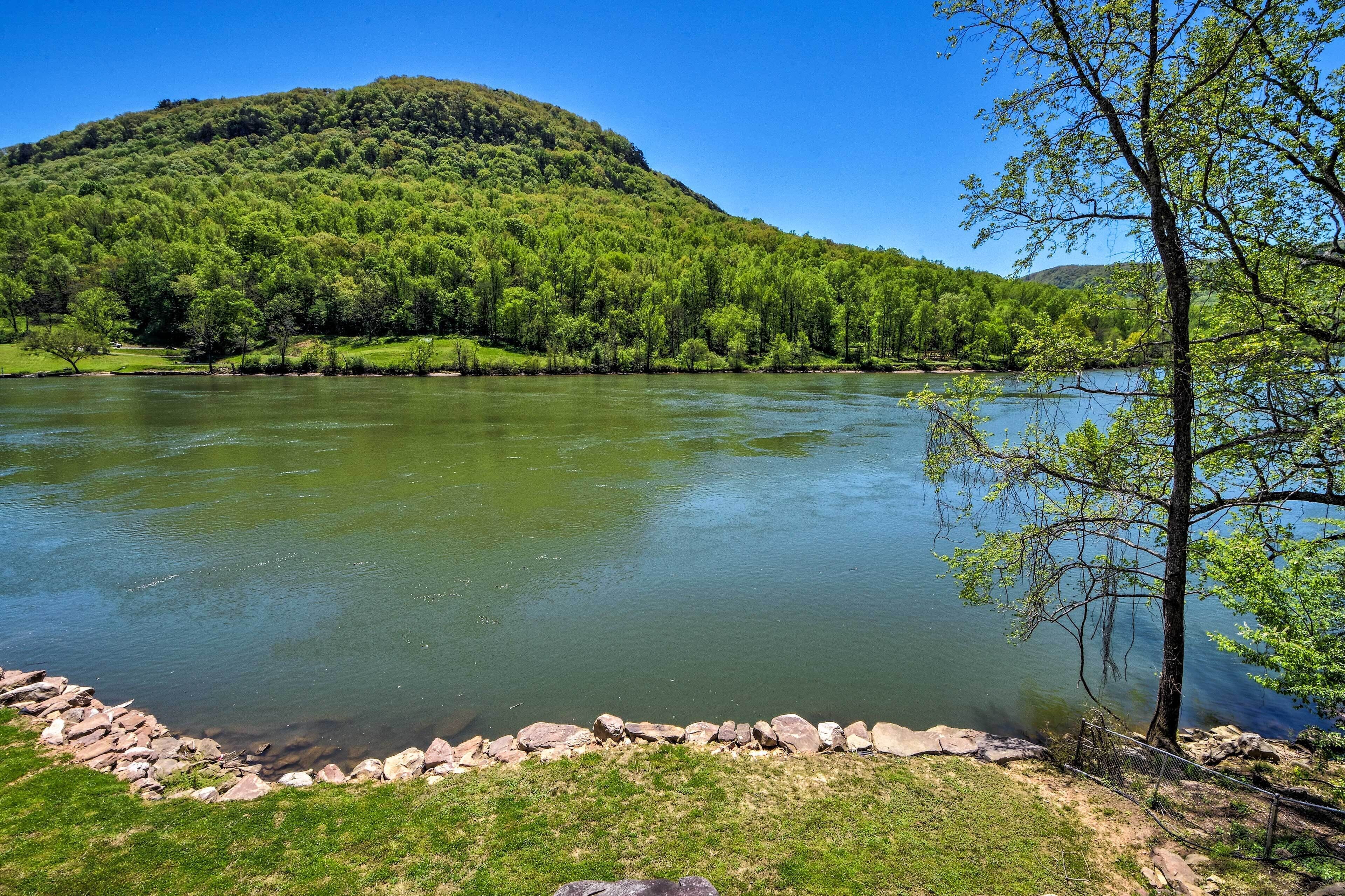 A river with a rocky shoreline and a grassy bank.