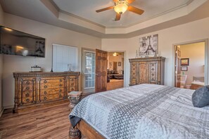 A bedroom with a large bed, wooden dresser, and a ceiling fan. - Branson Group Getaway: 2 Mi to Silver Dollar City! (Branson West)