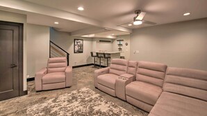 A living room with a sectional sofa, two recliner chairs, a ceiling fan, recessed lighting, a staircase, and a kitchen area with bar stools. - 5 Mi to Mercedes-benz Stadium: Stylish ATL Retreat (Atlanta)