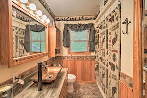 Une salle de bain avec un meuble-lavabo, un évier et des toilettes.