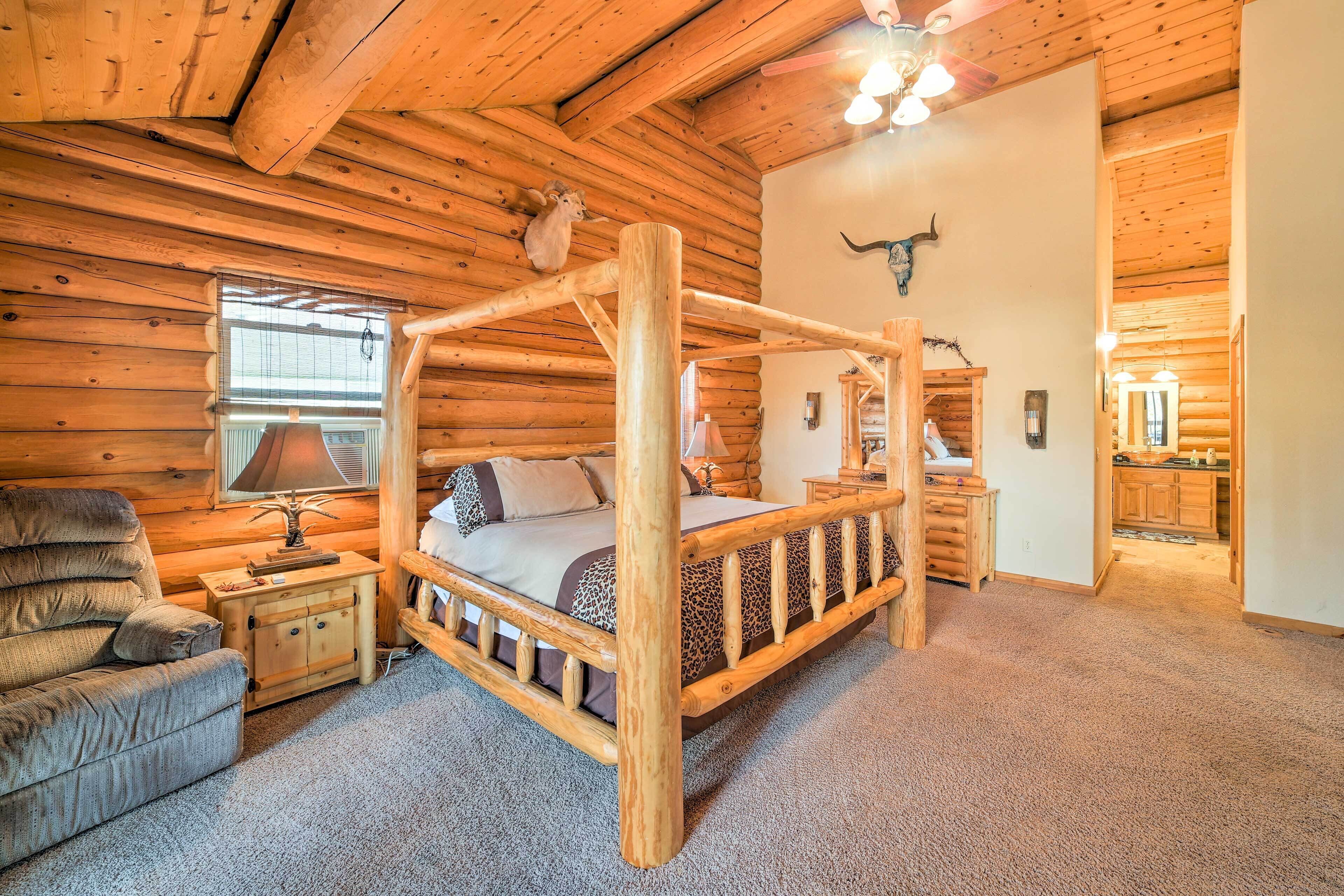 A log cabin interior with a four-poster bed, a sofa, and a dining area.