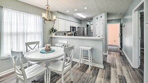 A modern kitchen with white cabinets, stainless steel appliances, and a central island. - Coastal Myrtle Beach Condo w/ Pool ~ 5 Mi to Beach (Myrtle Beach)