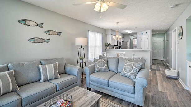 A modern living room with grey sofas, a coffee table, and decorative fish wall art. - Coastal Myrtle Beach Condo w/ Pool ~ 5 Mi to Beach (Myrtle Beach)