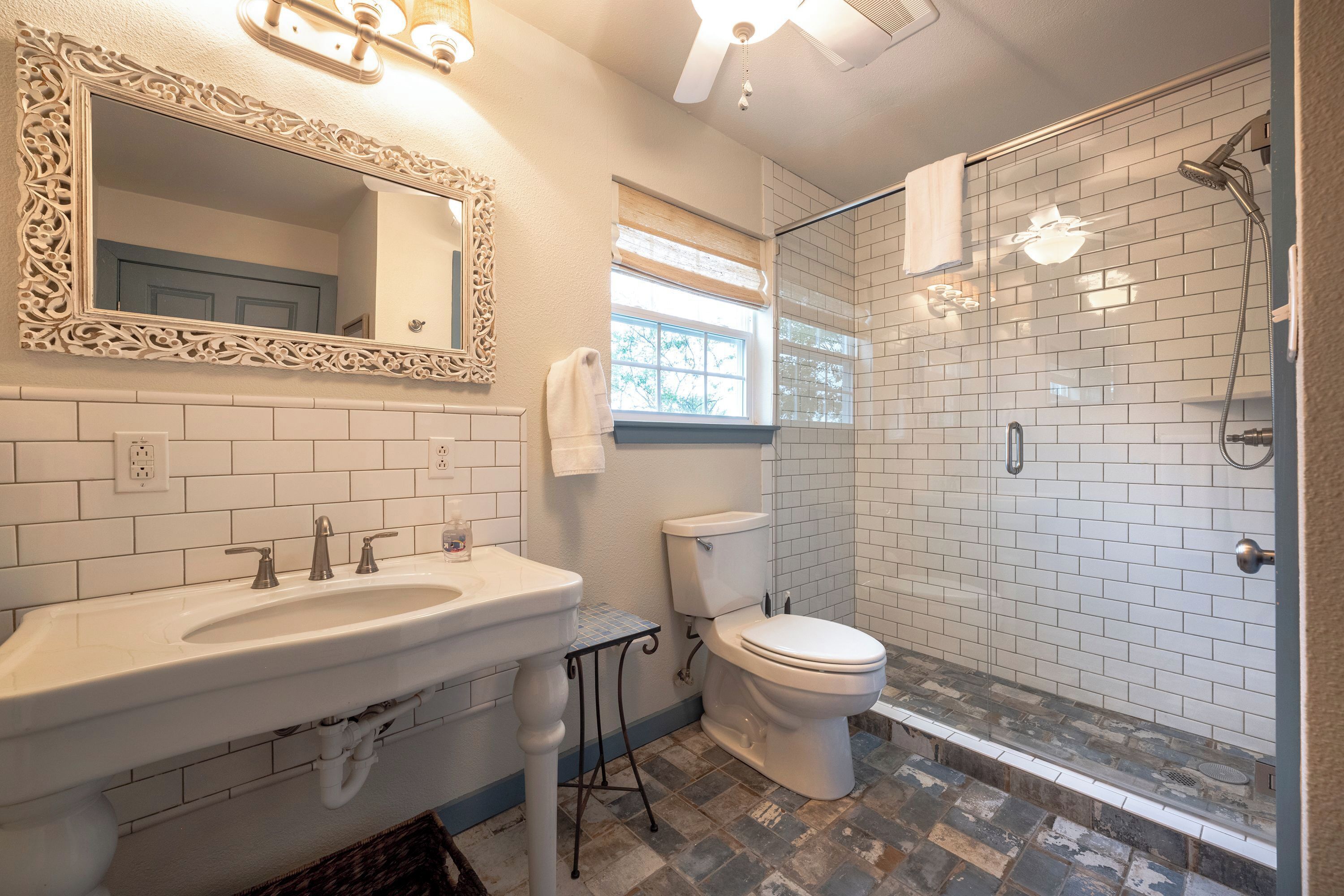 A bathroom with a white sink, a toilet, and a shower with a glass door.
