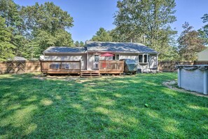 A single-story house with a fenced backyard, a covered patio, and a small deck.