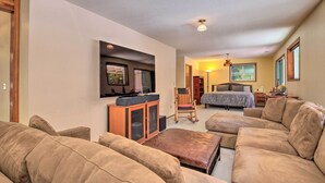 A living room with a sofa set, a TV mounted on the wall, a bed, and a chair. - Spacious Kalama Studio w/ Riverfront Deck! (Kalama)