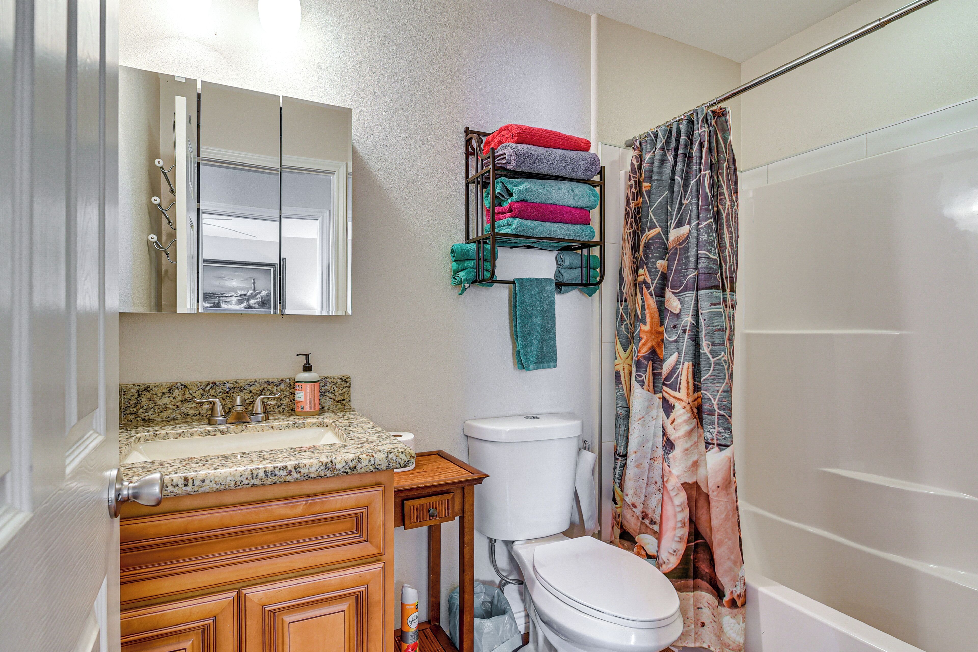 Une salle de bain avec un lavabo, des toilettes et un rideau de douche.