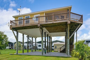Een huis met twee verdiepingen, een balkon en een overdekte patio, en een schotelantenne.