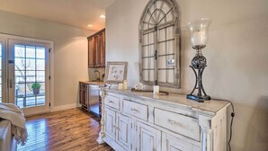 A room with a wooden floor, a white dresser, a large arched window, and a lamp. - Group Winter Retreat! Stunning Villa Near SDC (Branson)