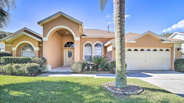 A two-story house with a garage, a front entrance with an archway, and a well-maintained lawn. - 12 Miles to Disney: Clermont Villa w/ Heated Pool (Clermont)