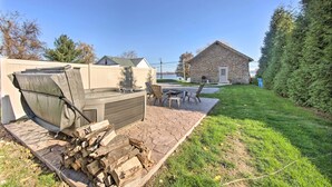 Un patio con chimenea de piedra, mobiliario exterior y un edificio de piedra al fondo.