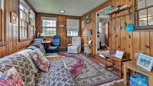 A cozy room with a large bed, a desk, a chair, and a window with blinds. - Saybrook Manor House, Walk to Cove Beach! (Old Saybrook)