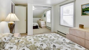 A bedroom with a bed, a dresser, a lamp, a painting, and a window with blinds. - Historic Carriage House < 20 Mi Elk Mtn: Hike, Ski (Lakewood)