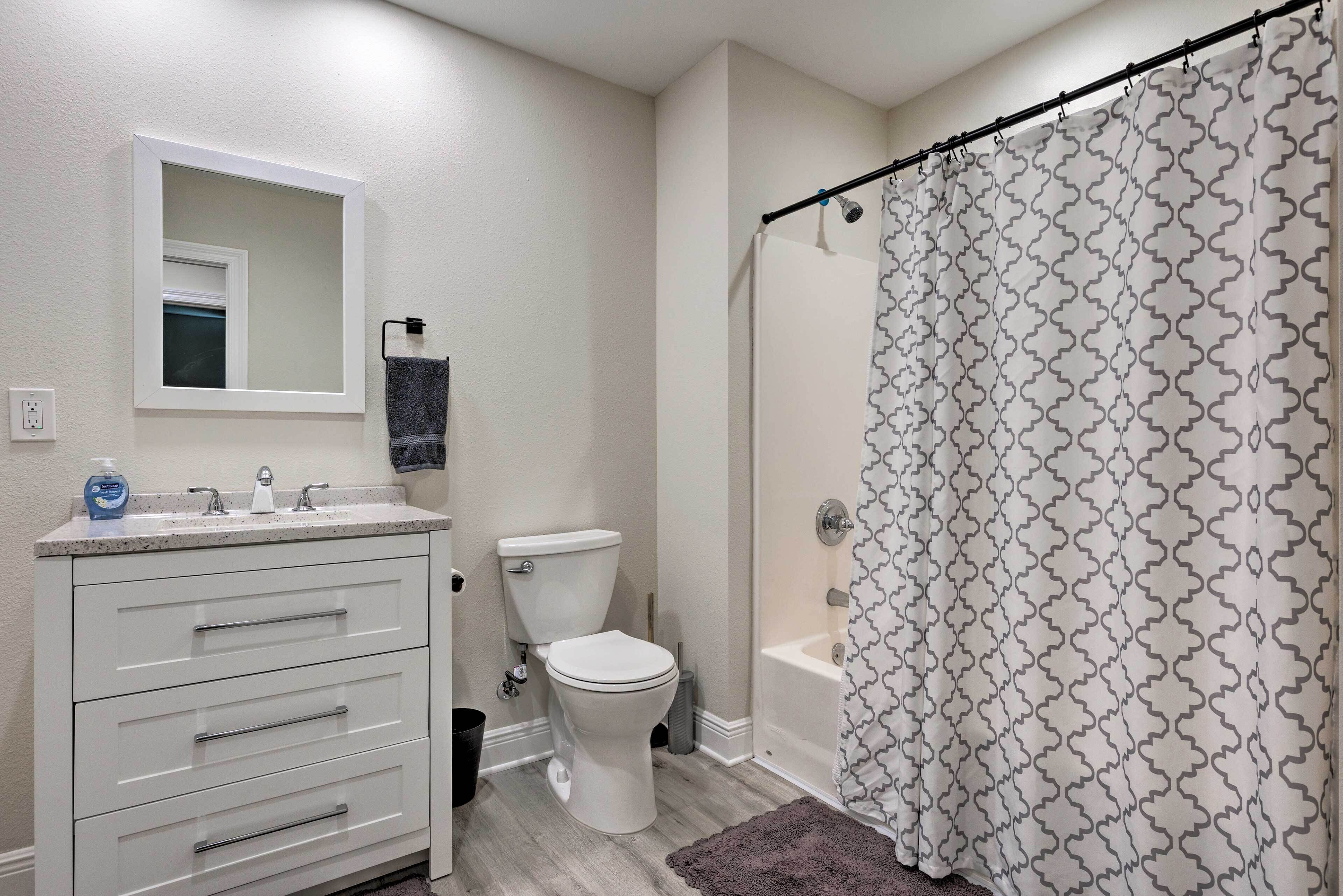A bathroom with a toilet, sink, and shower curtain.