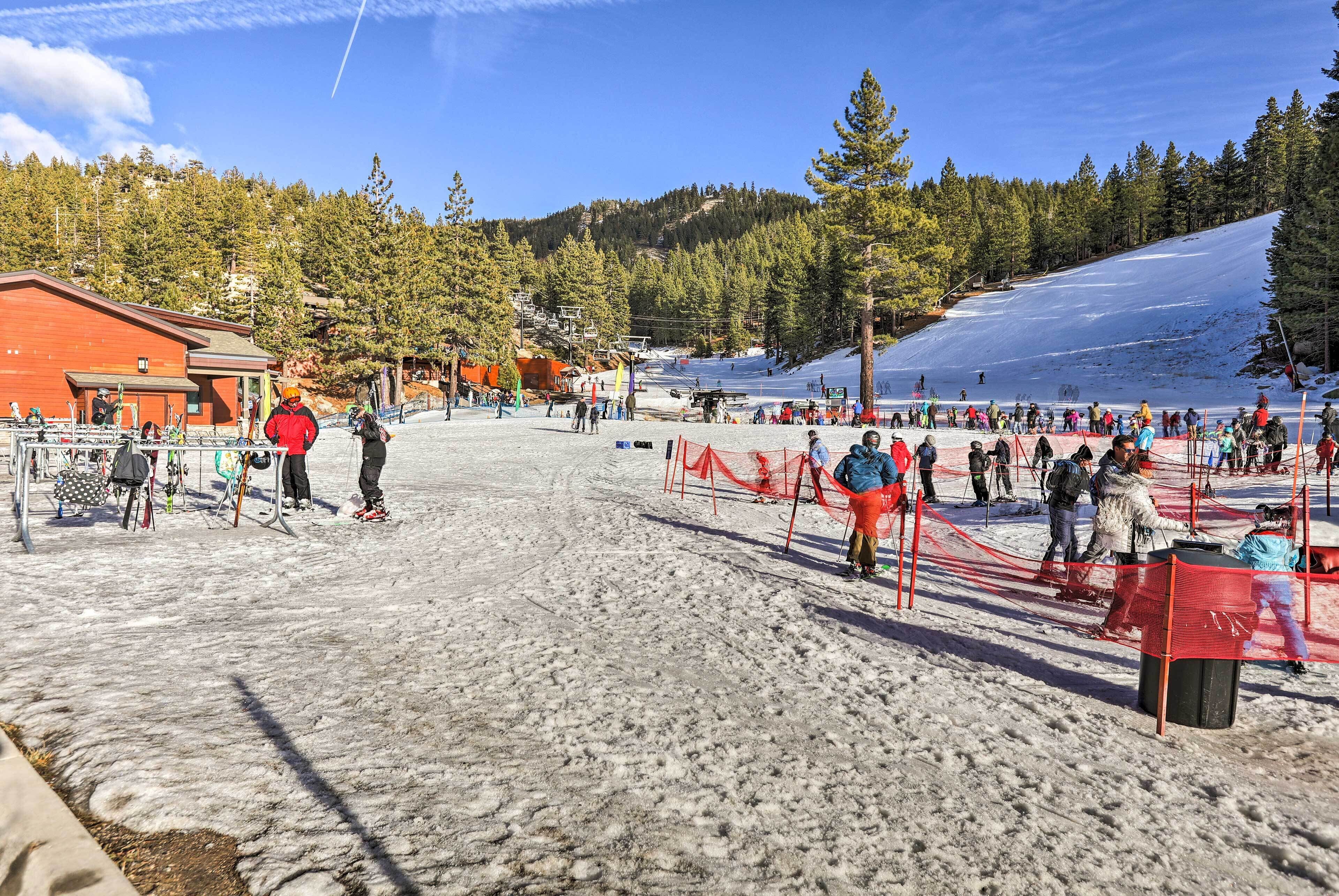A ski resort with a red building, ski lifts, and a snow-covered slope.