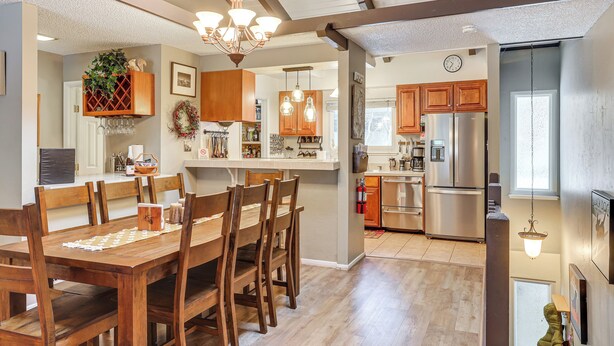 A spacious kitchen with wooden cabinets, a stainless steel refrigerator, and a dining area with a wooden table and chairs. - 1 Mi to Diamond Peak Ski Resort: Forest-view Condo (Incline Village)