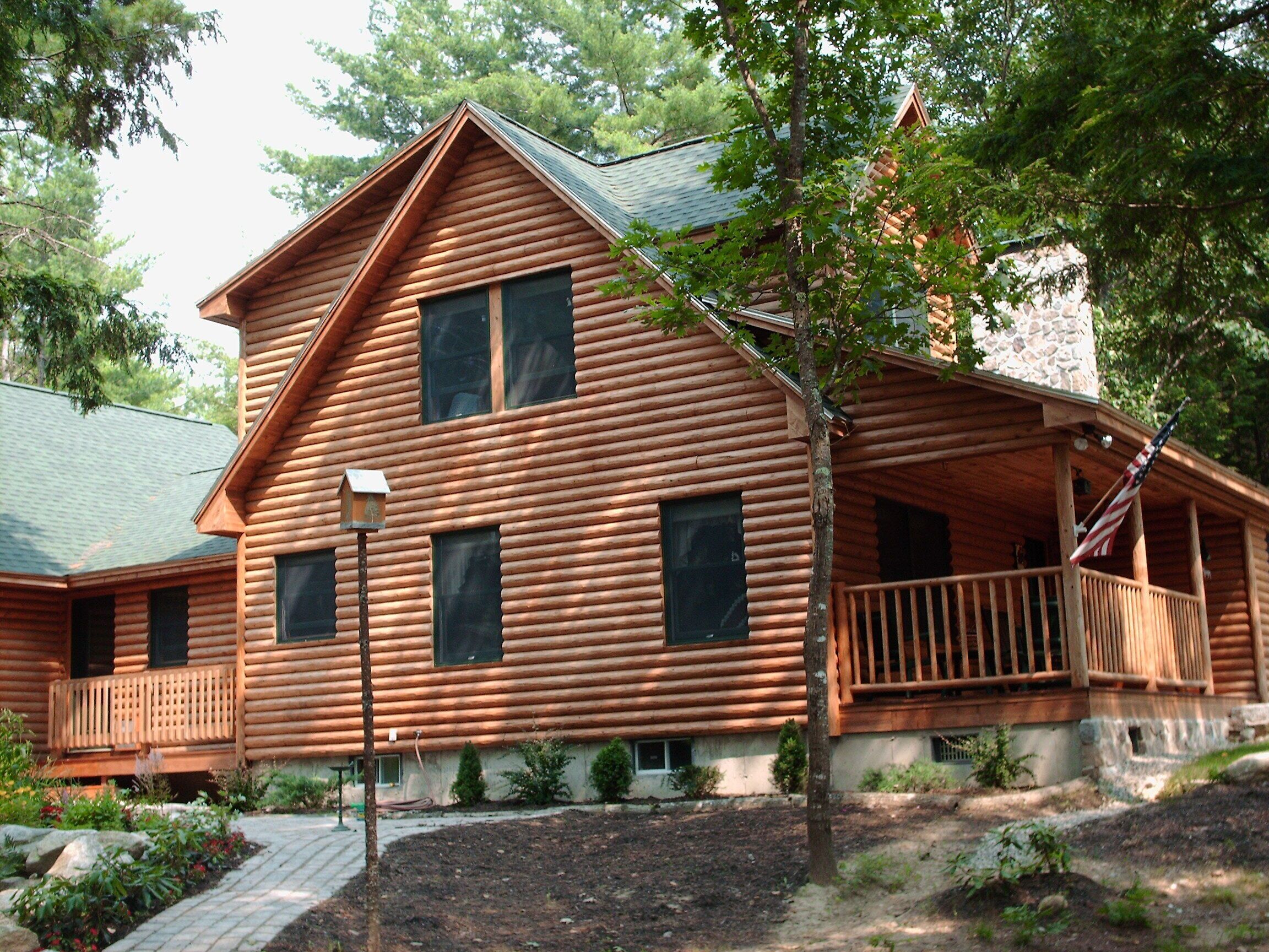 A log cabin with a porch and a chimney.