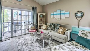 A living room with a sofa, coffee table, and artwork on the wall. - Lovely Myrtle Beach Condo: 4 Mi to Boardwalk! (Myrtle Beach)