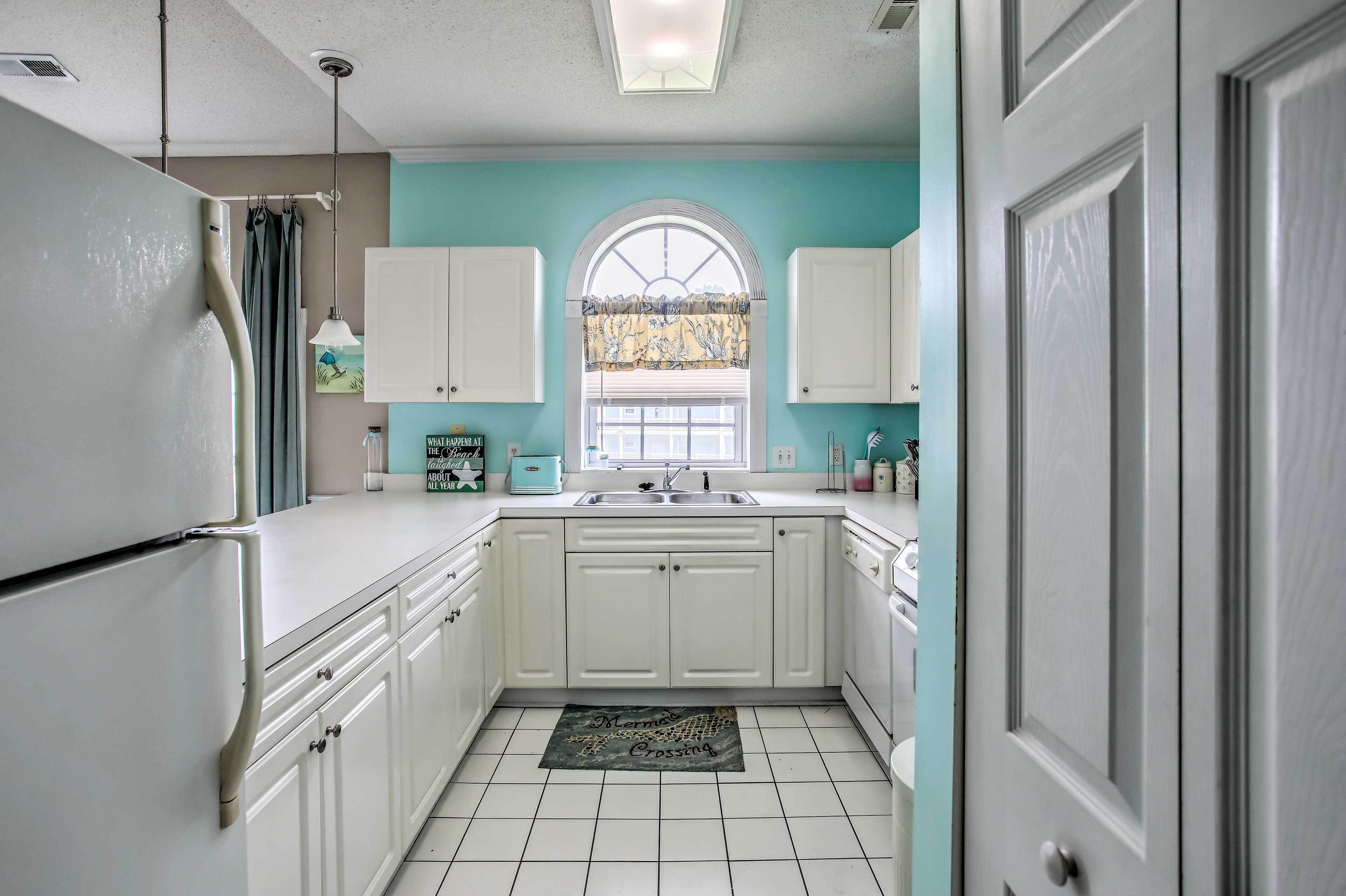 A kitchen with white cabinets, a sink, and a window with a decorative curtain.