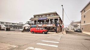 A building with a 'CASINO' sign, a red van parked in front, and a crosswalk. - Cozy Hampton Cottage w/ BBQ - Walk to Ocean! (Hampton)