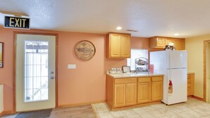 A kitchen with wooden cabinets, a white refrigerator, and an exit sign. - 5 Mi to Terry Peak Slopes: Quiet Apt w/ Patio! (Lead)