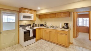 A kitchen with wooden cabinets, a microwave, stove, and various appliances. - 5 Mi to Terry Peak Slopes: Quiet Apt w/ Patio! (Lead)