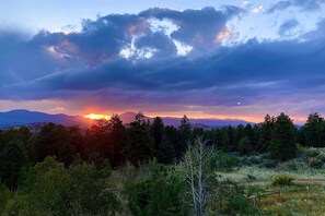 A landscape with a sunset, trees, and mountains in the background. - Lake George Cabin w/ Deck & Mountain Views! (Lake George)