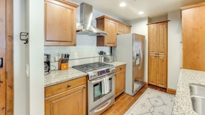 A kitchen with wooden cabinets, stainless steel appliances, and a granite countertop. - Half-mi to Payette Lake: Dtwn Mccall Condo! (McCall)