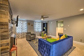 A living room with a blue sofa, a coffee table, and a ceiling fan. - Charming Apt W/patio: Walk to Downtown Albany (Albany)