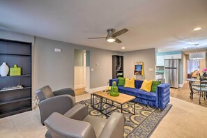 A modern living room with a blue sofa, grey chairs, a coffee table, and a ceiling fan. - Charming Apt W/patio: Walk to Downtown Albany (Albany)