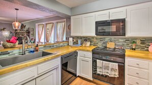 A modern kitchen with white cabinets, a stainless steel sink, a microwave, and a dishwasher. - Mount Ida Condo w/ Balcony + Resort Amenities (Mount Ida)