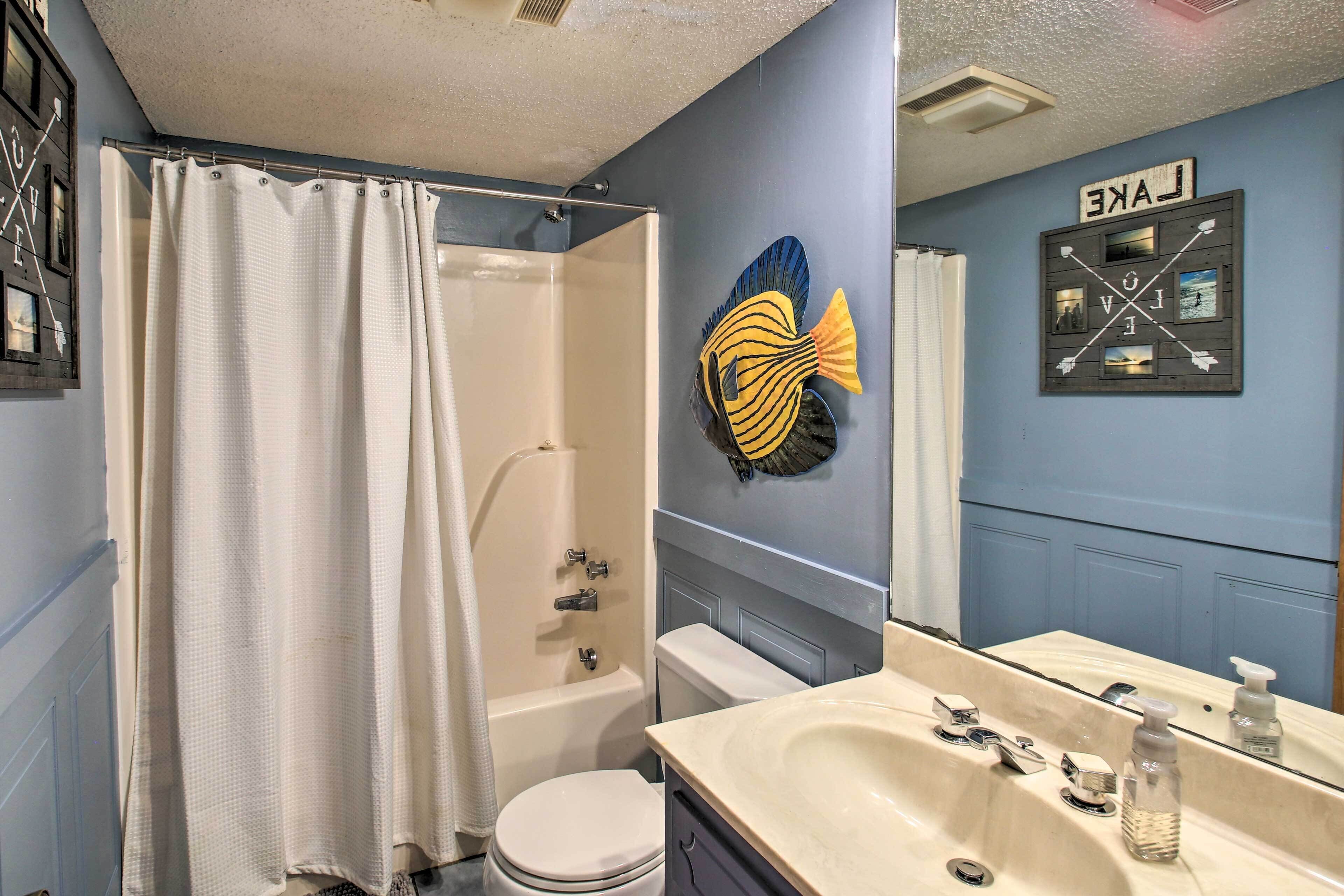 A bathroom with a bathtub, toilet, and sink.