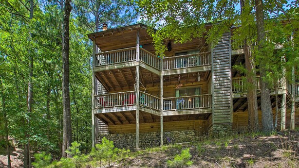 A multi-story wooden cabin with balconies, surrounded by trees. - Mount Ida Condo w/ Balcony + Resort Amenities (Mount Ida)