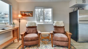 A cozy kitchen with two leather chairs, a wooden table, a lamp, a painting, and a refrigerator. - Goldendale Vacation Rental 13 Mi to Columbia River (Goldendale)