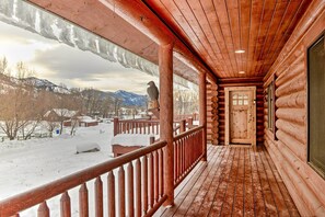 A wooden log cabin with a covered porch and a view of a snowy landscape. - Charming Bedford Cabin w/ Private Hot Tub! (Bedford)