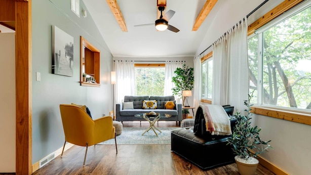 A modern living room with a sofa, armchairs, a coffee table, and a ceiling fan. - Lakeside Indiana Vacation Rental Near Fort Wayne! (Churubusco)