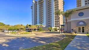 A multi-story hotel with a central courtyard, a fountain, and a parking area.