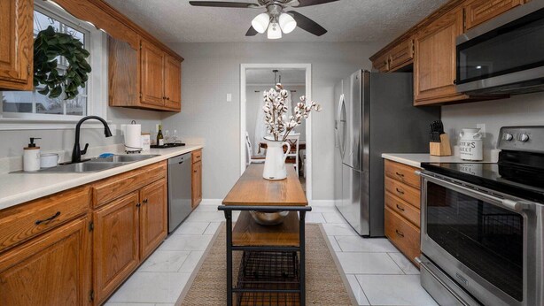 A modern kitchen with wooden cabinets, stainless steel appliances, and a central island. - Single-story Manchester Home Close to Parks! (Manchester)