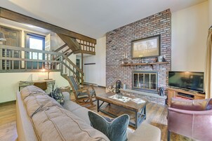 A cozy living room with a fireplace, a sofa, a coffee table, and a television.