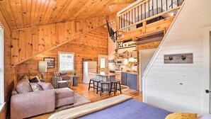 A cozy cabin interior with a loft bedroom, a dining area, and a kitchen. - Updated Mtn View Studio w/ Loft - Near River! (Mountain View)