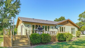 A two-story house with a front porch, a staircase, and a small front yard with bushes. - Kayaks & Boat Dock: Waterfront Home in Grove (Grove)