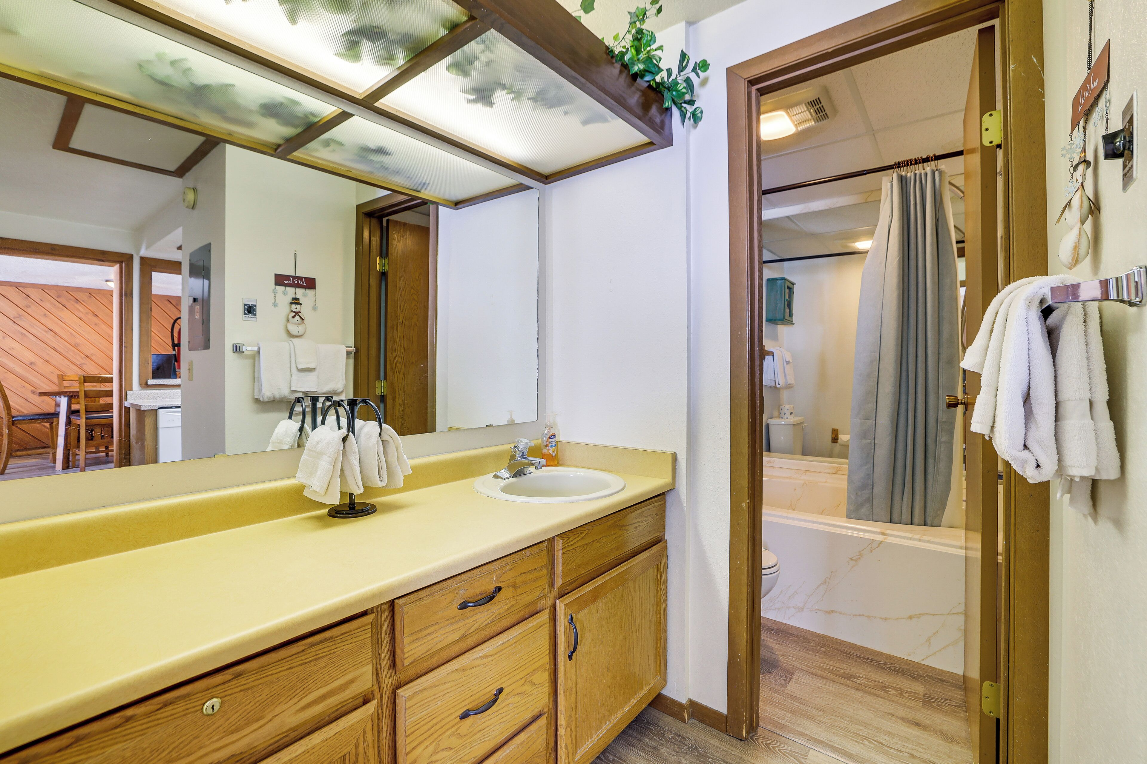 A bathroom with a wooden vanity, a sink, and a mirror.
