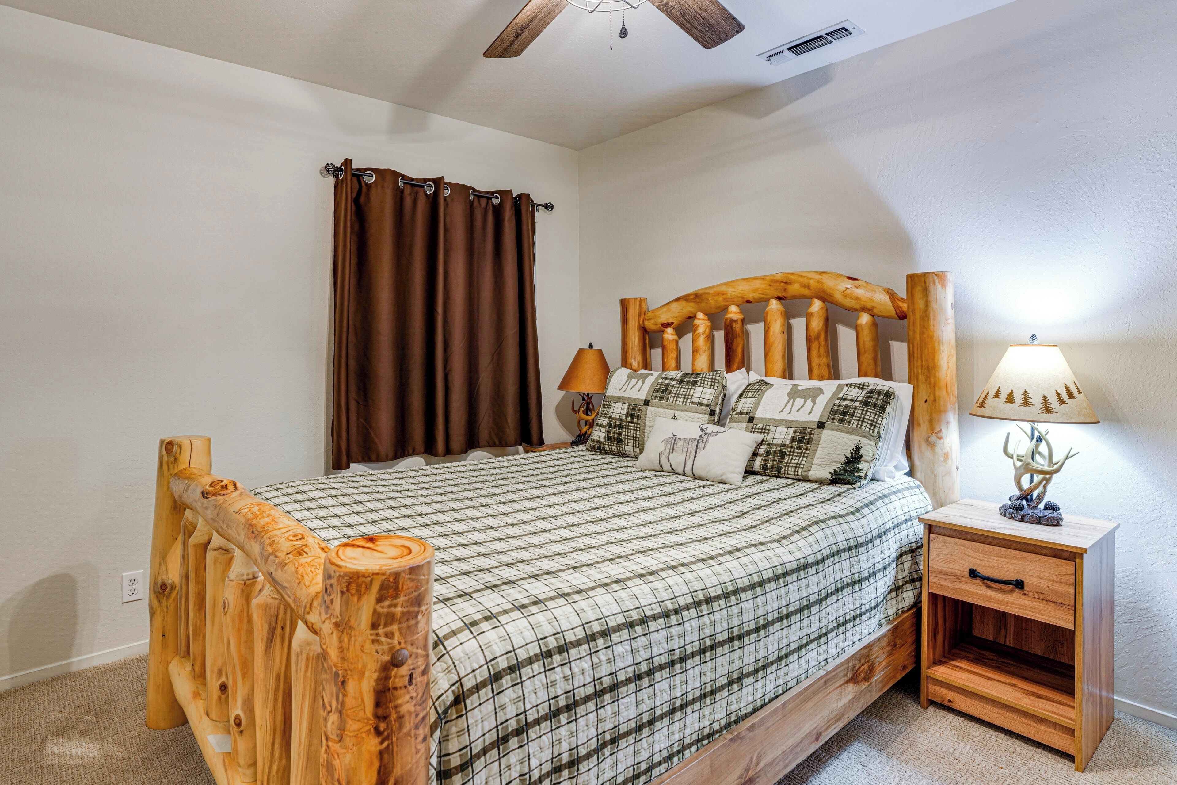 A bedroom with a wooden bed frame, a nightstand with a lamp, and a window with curtains.