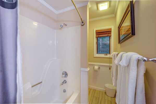 A bathroom with a bathtub, a shower, a window with blinds, and a towel rack. - Family Cabin & Deep Gap Game Room & Scenic Views (Deep Gap)
