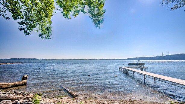 A rocky shoreline with a wooden dock extending into calm water. - Waterfront Home w/ Hot Tub in Wrightsville! (Wrightsville)