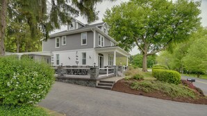 A two-story house with a porch, stone steps, and a driveway. - Waterfront Home w/ Hot Tub in Wrightsville! (Wrightsville)