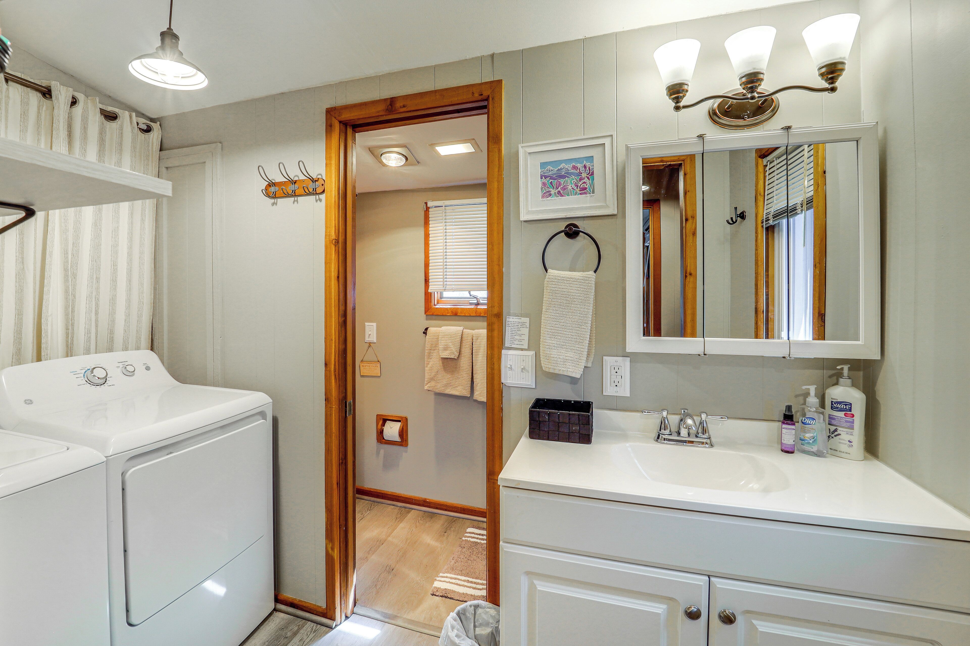 A modern bathroom with a white sink, mirror, and towel rack.